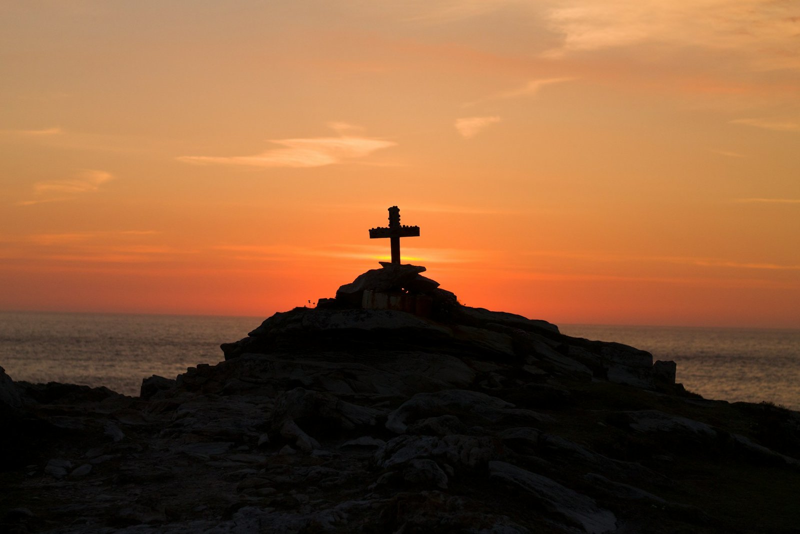 silhueta de uma cruz na montanha