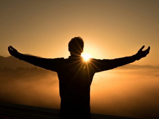silhueta de um homem no penhasco ao pôr do sol
