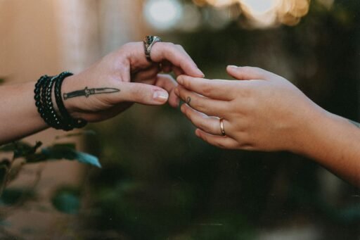 duas mãos tatuadas se tocando