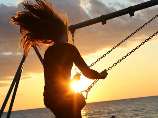 mulher sentada no balanço durante o pôr do sol